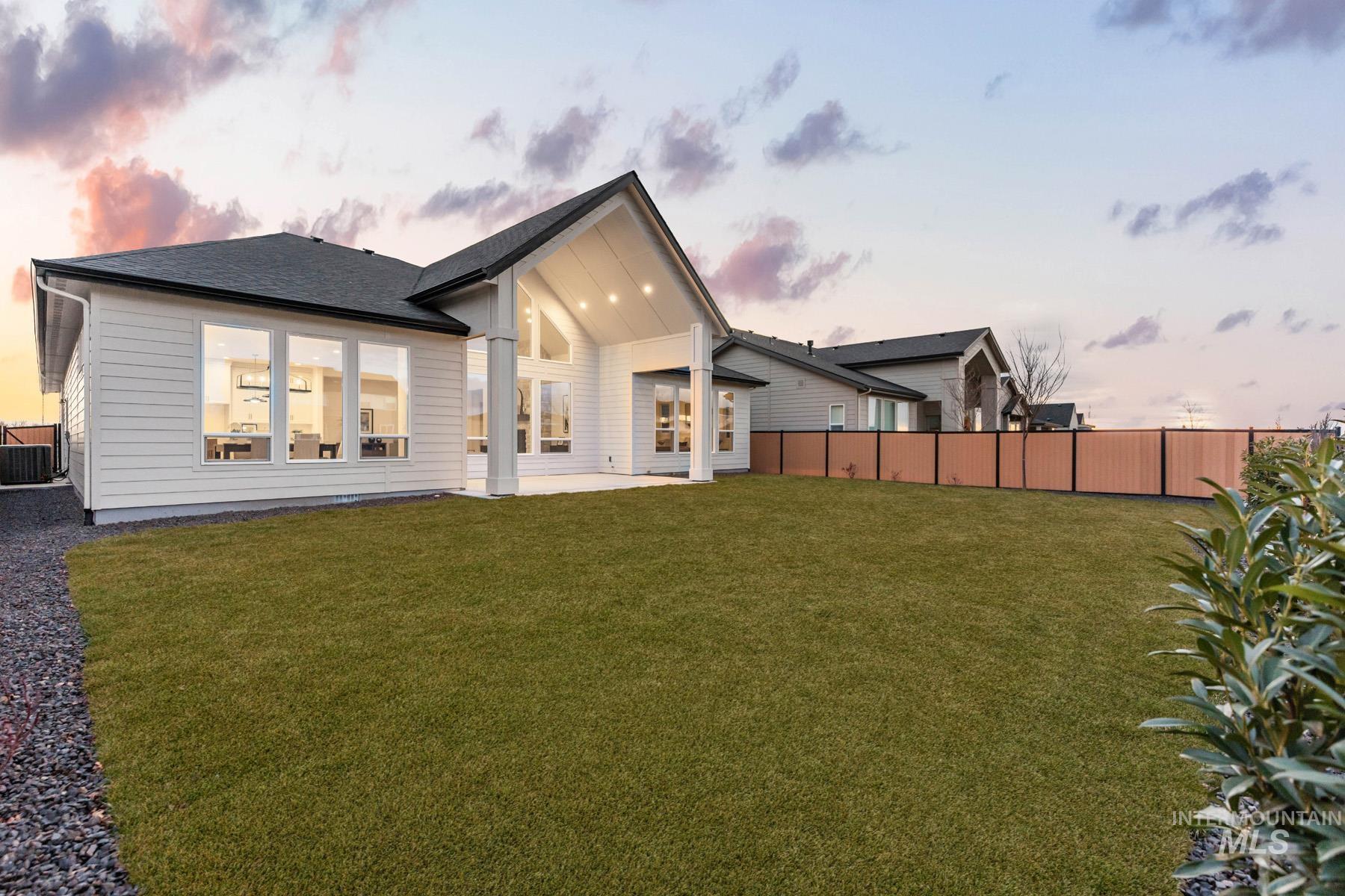 6954 Saddle Bred Way Star, ID 83669 - Photo 35 of 49 Back of house at dusk featuring a patio area, a fenced backyard, and roof with shingles