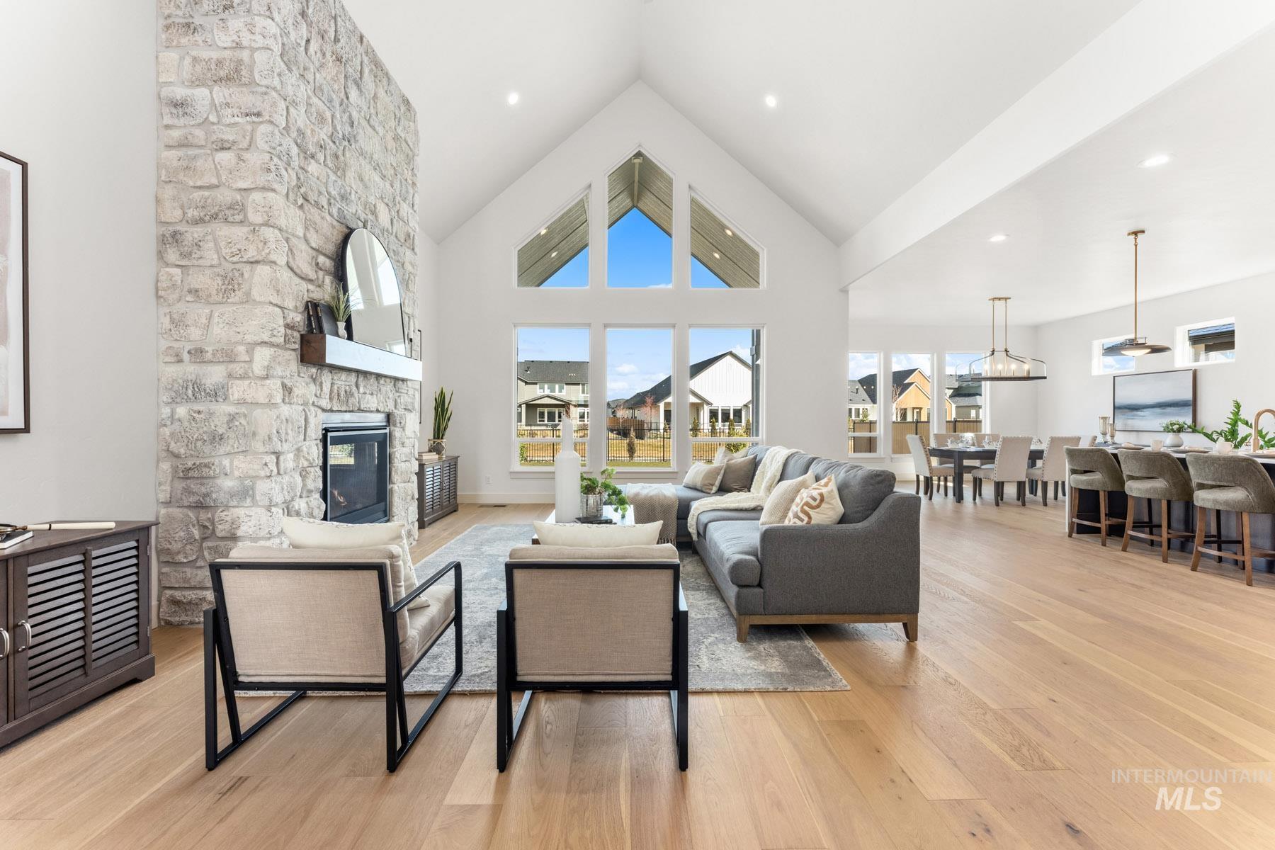 6954 Saddle Bred Way Star, ID 83669 - Photo 6 of 49 Living room with a fireplace, light wood-style floors, and a high ceiling