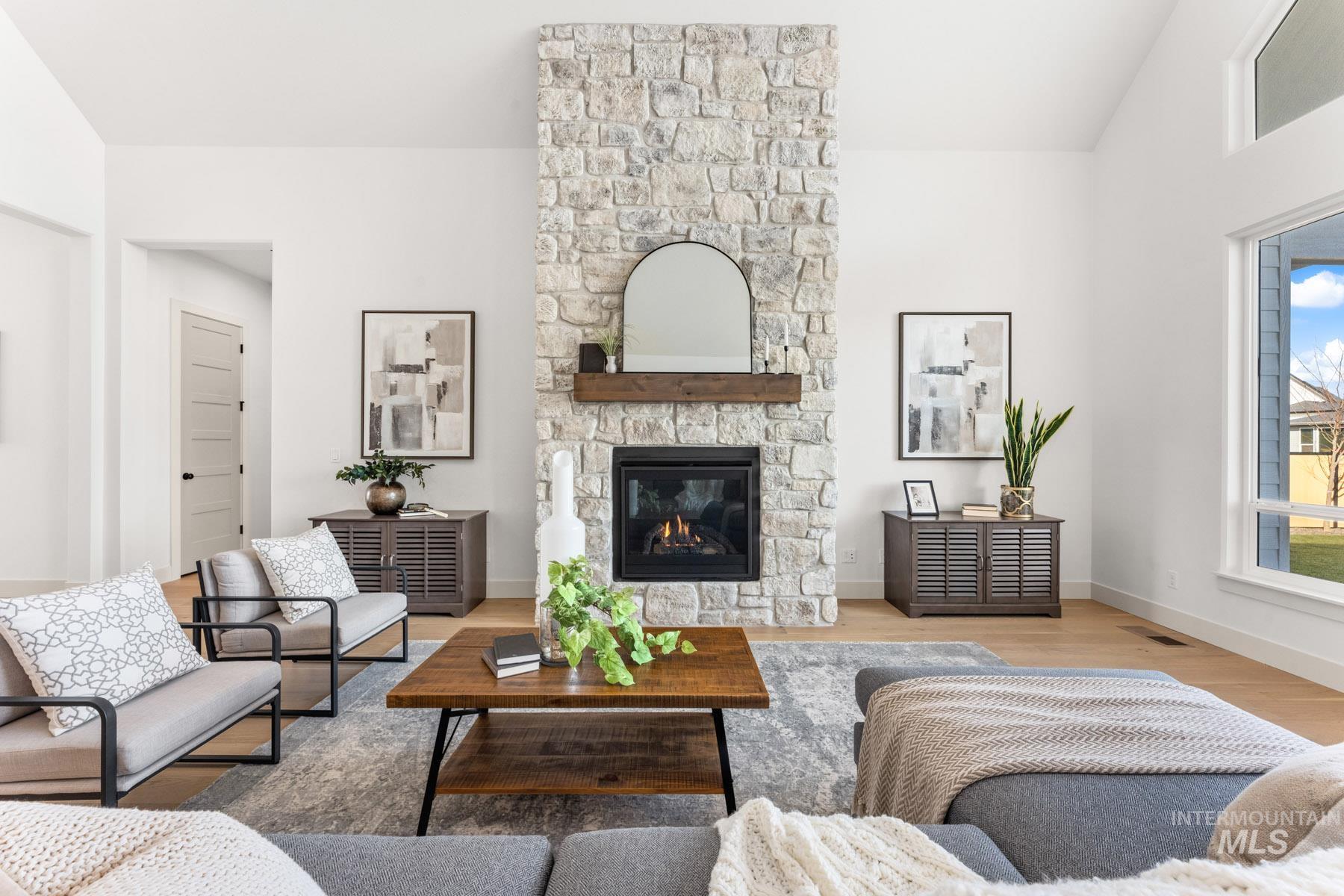 6954 Saddle Bred Way Star, ID 83669 - Photo 6 of 50 Living room with lofted ceiling, light wood-style floors, and a fireplace