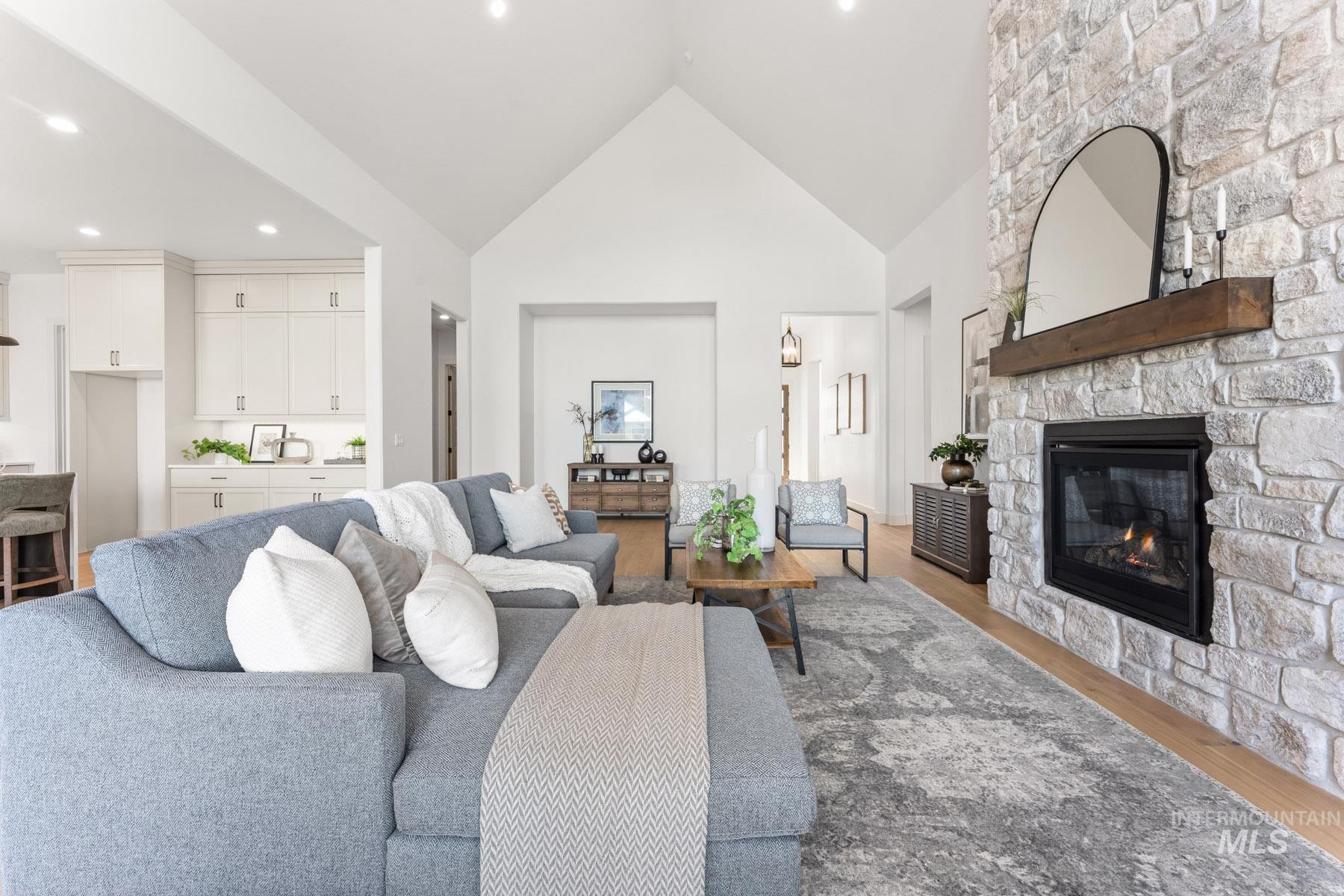 6954 Saddle Bred Way Star, ID 83669 - Photo 8 of 50 Living room with a high ceiling, wood finished floors, a stone fireplace, and recessed lighting