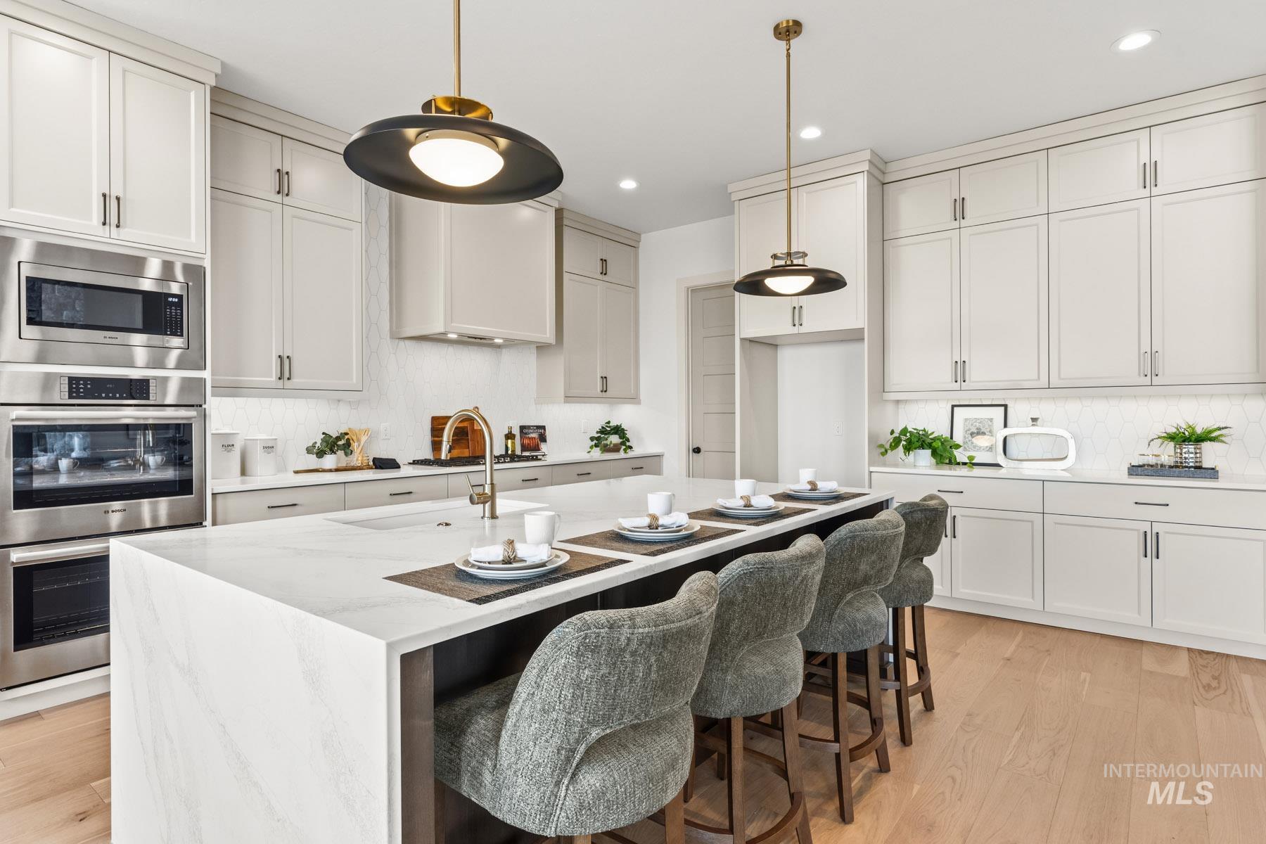 6954 Saddle Bred Way Star, ID 83669 - Photo 10 of 49 Kitchen featuring decorative backsplash, stainless steel appliances, light stone countertops, and light wood-type flooring