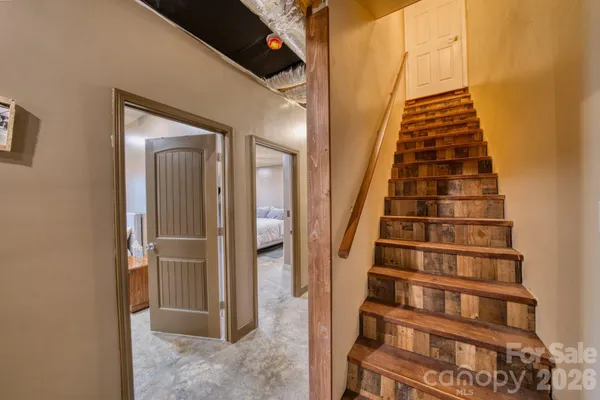 a view of staircase with white walls and railing
