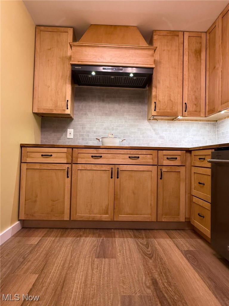 4017 Kibler Toot Road Southwest Warren, OH 44481 - Photo 17 of 30 Kitchen featuring tasteful backsplash, light hardwood / wood-style flooring, and custom exhaust hood