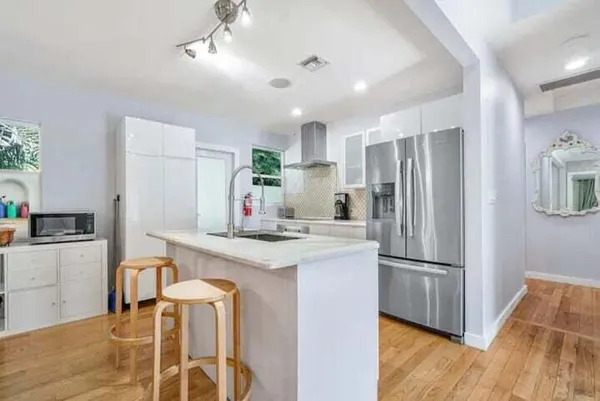 a kitchen with refrigerator cabinets and wooden floor