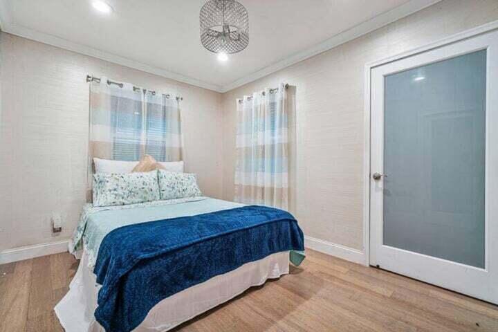 11 Southwest 4th Street Delray Beach, FL 33444 - Photo 16 of 27 a bedroom with a large bed and a chandelier