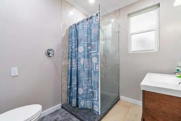 a bathroom with a shower a toilet and a sink