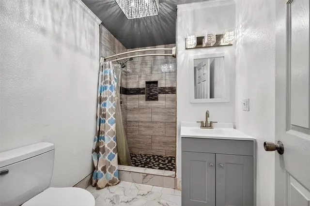 a bathroom with a sink toilet and shower