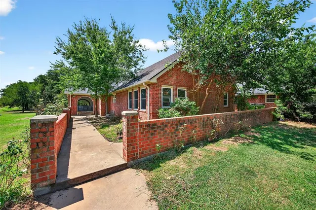 a view of a house with backyard and a tree