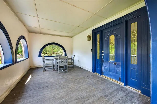 wooden floor with a view of a dining room with a window