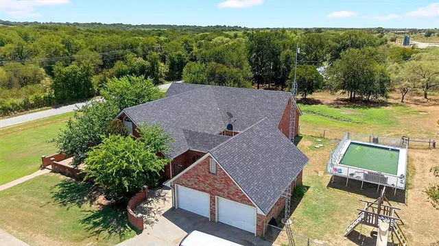 an aerial view of a house with garden space and street view
