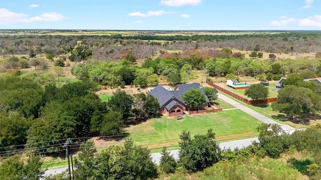 an aerial view of residential houses with outdoor space and ocean