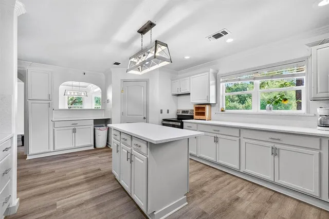 a kitchen with a sink window and cabinets