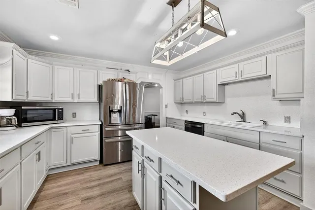 a kitchen with stainless steel appliances a refrigerator sink and cabinets