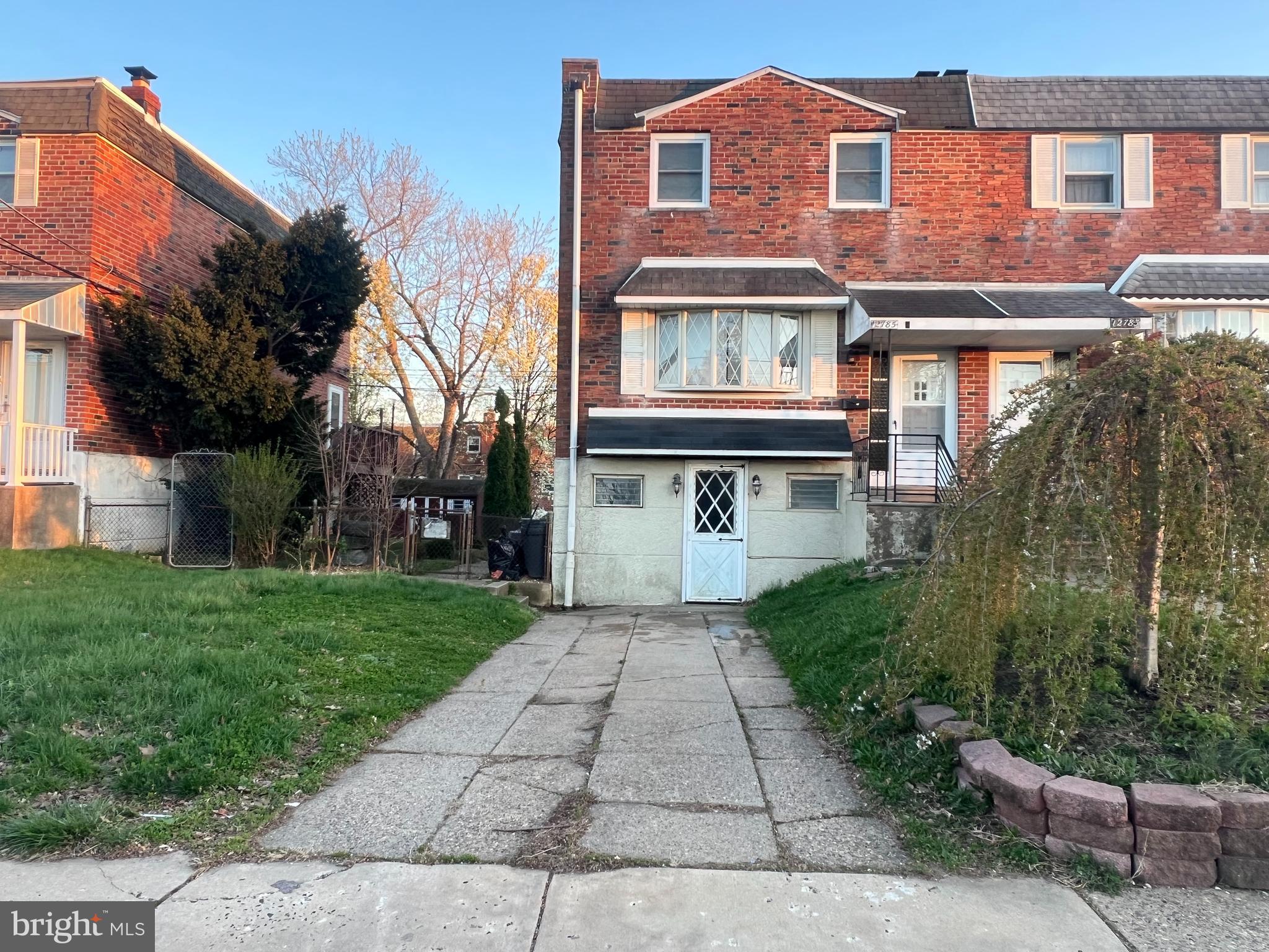 a front view of a house with a yard and potted plants