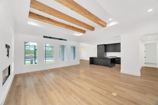 a large bedroom with a bed and wooden floor