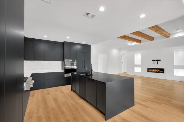 a large kitchen with stainless steel appliances a large counter top
