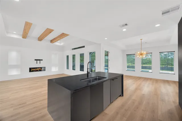 a kitchen with granite countertop a sink a counter top space and living room area
