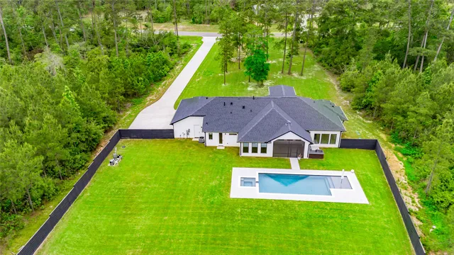 an aerial view of a houses with a yard