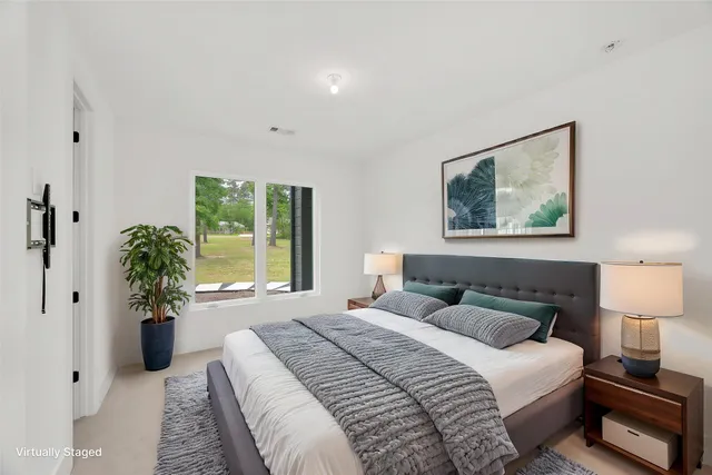 a bedroom with a large bed and a potted plant