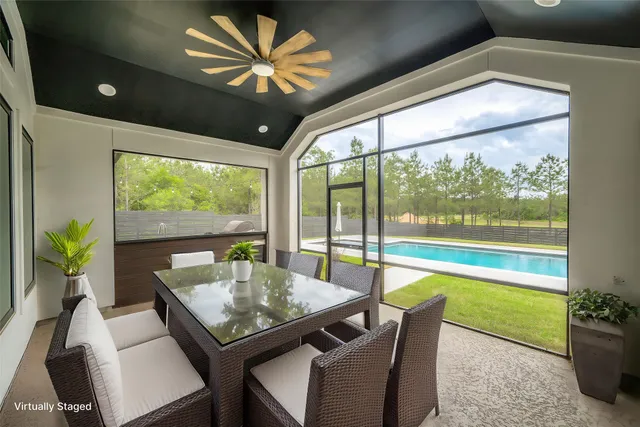 a dining room with furniture a chandelier and a large window