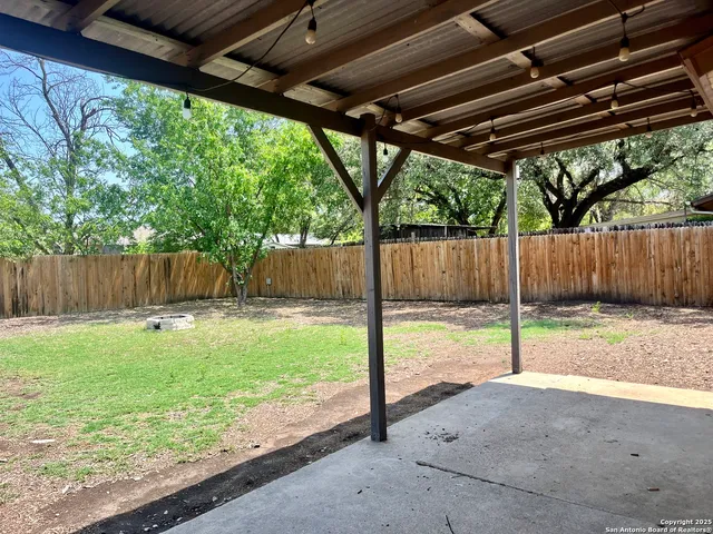 a view of a backyard with wooden fence