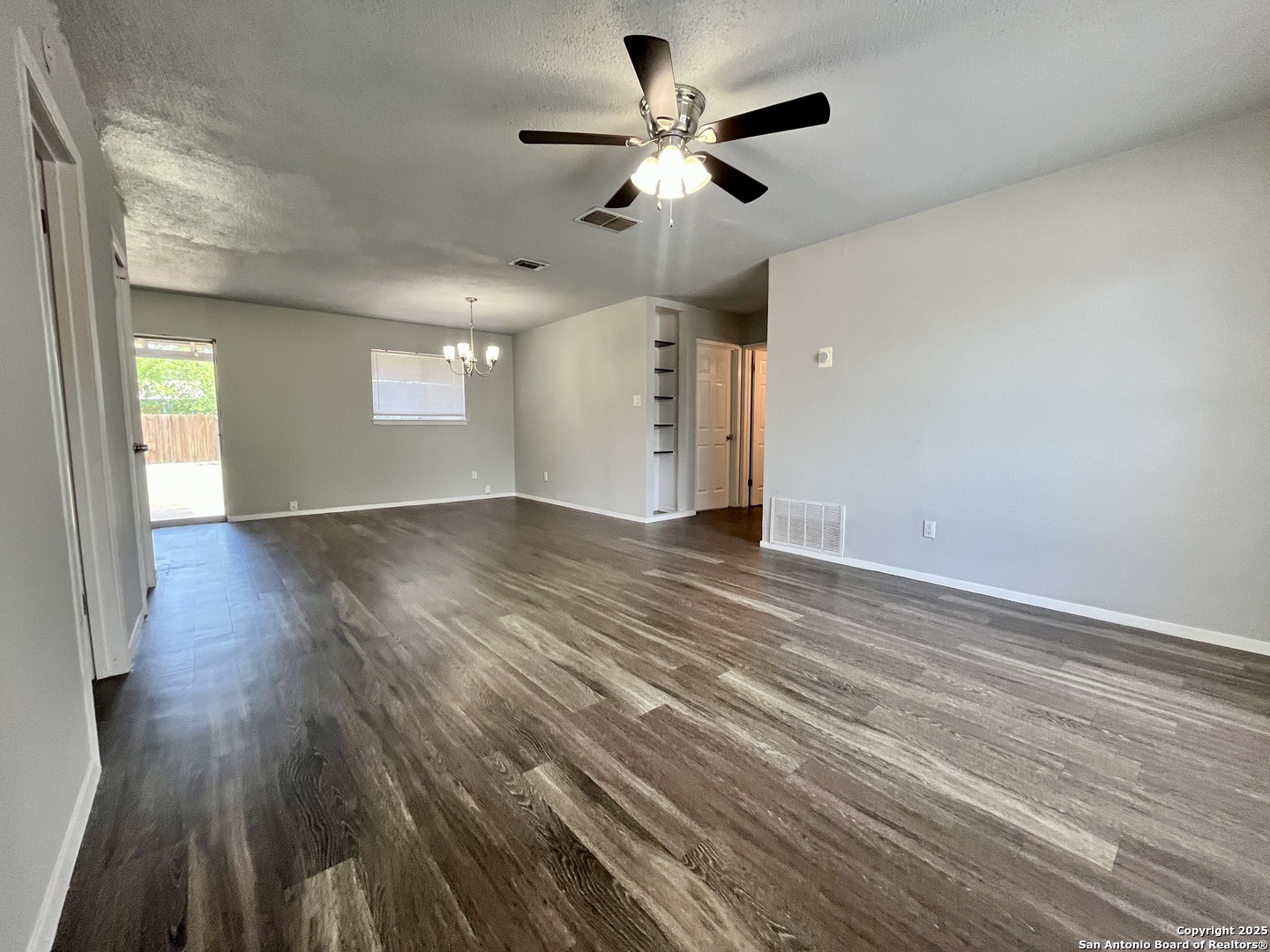 5019 Ed White Street Kirby, TX 78219 - Photo 2 of 15 wooden floor in an empty room with a window