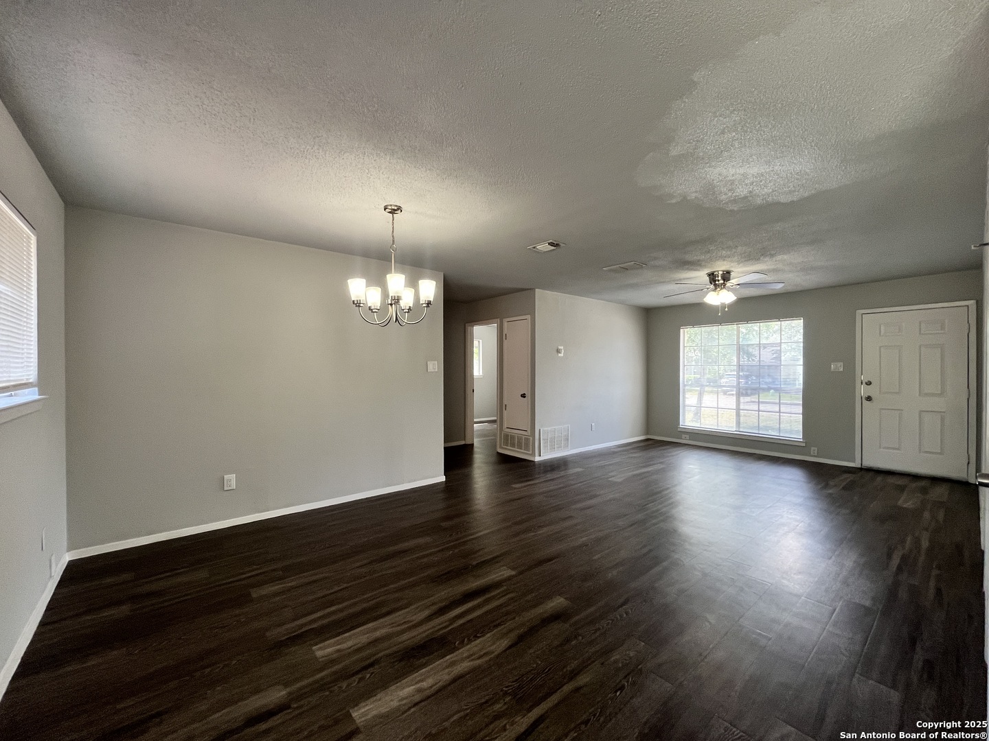 5019 Ed White Street Kirby, TX 78219 - Photo 3 of 15 an empty room with wooden floor and windows