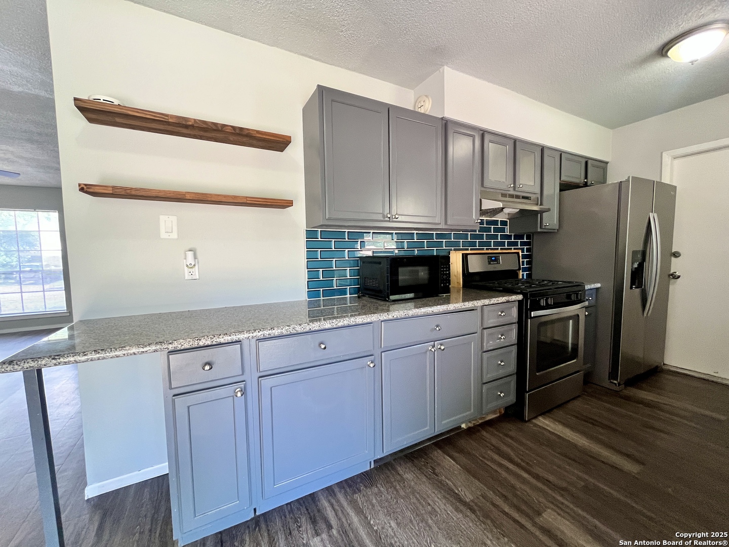5019 Ed White Street Kirby, TX 78219 - Photo 6 of 15 a kitchen with stainless steel appliances a refrigerator sink and cabinets