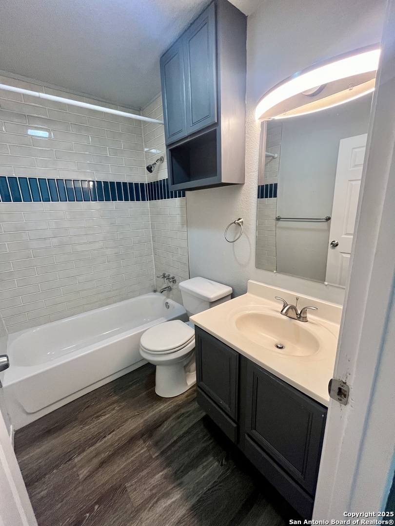 5019 Ed White Street Kirby, TX 78219 - Photo 10 of 15 a bathroom with a sink toilet a mirror and bathtub