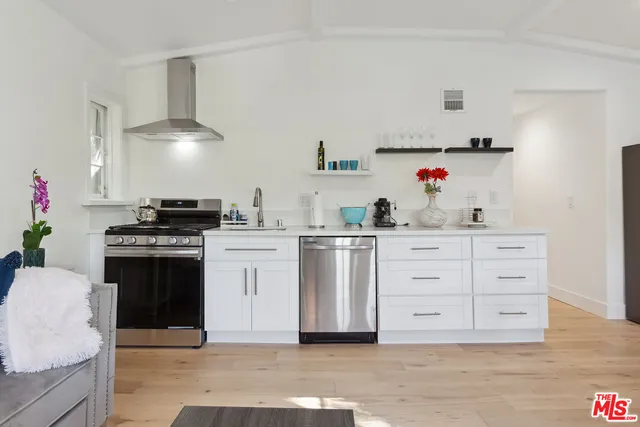 a kitchen with cabinets appliances and wooden floor