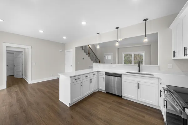 a kitchen with stainless steel appliances granite countertop a sink a stove a refrigerator and island with wooden floor