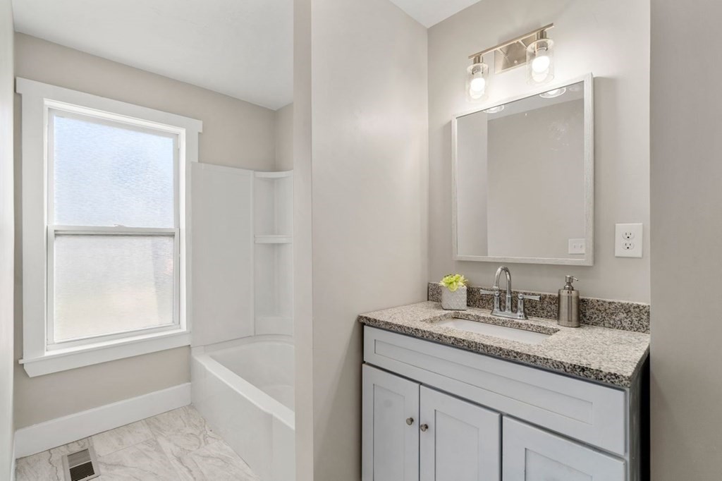 35-41 Watch Street Rochdale, MA 01542 - Photo 27 of 42 a bathroom with a granite countertop sink a mirror and a bathtub