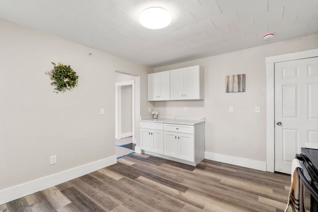 35-41 Watch Street Rochdale, MA 01542 - Photo 8 of 42 a view of a kitchen with white cabinets and wooden floor