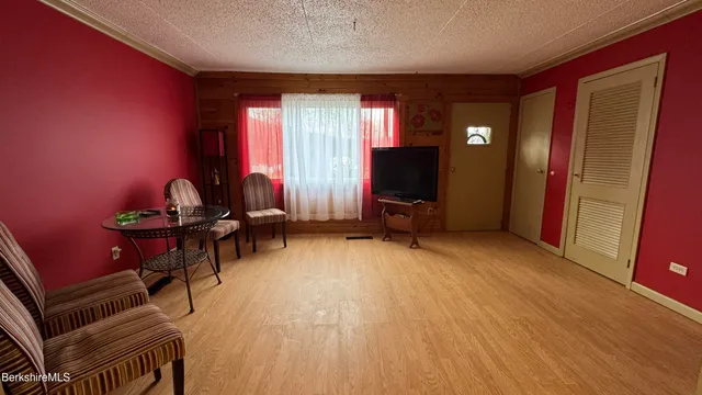 a view of a livingroom with furniture a piano and wooden floor