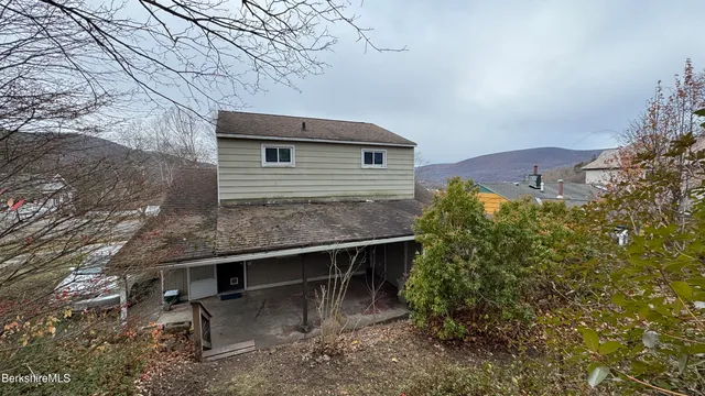 a backyard of a house with table and chairs