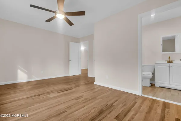 a view of empty room with wooden floor