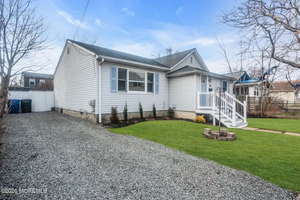 a front view of house with a garden and trees