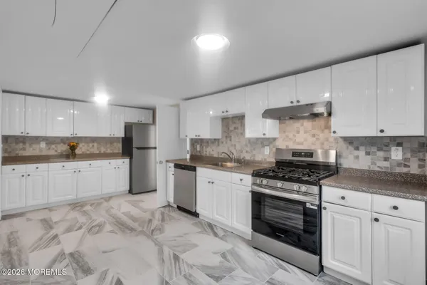 a kitchen with stainless steel appliances granite countertop a stove a sink and a refrigerator