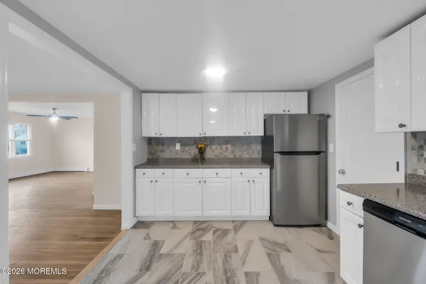 a kitchen with white cabinets and stainless steel appliances