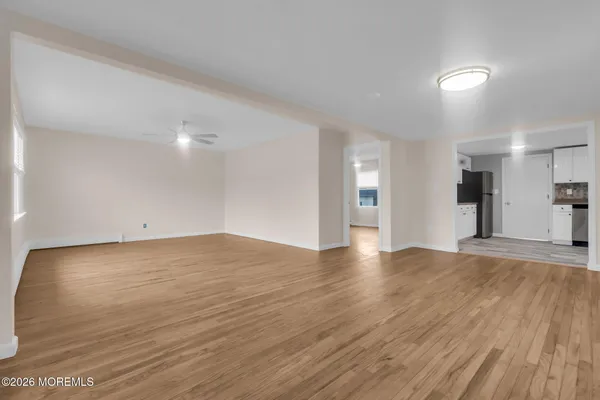 a view of empty room with wooden floor