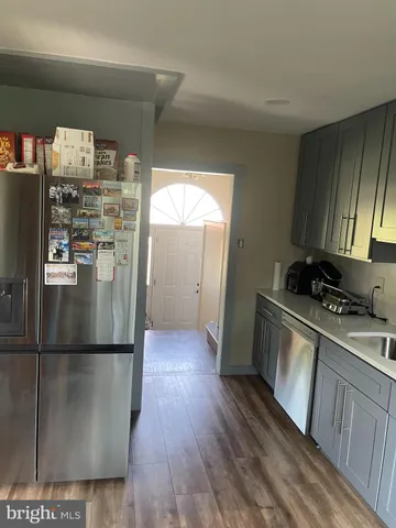 a kitchen with stainless steel appliances granite countertop a refrigerator a stove and a wooden floors