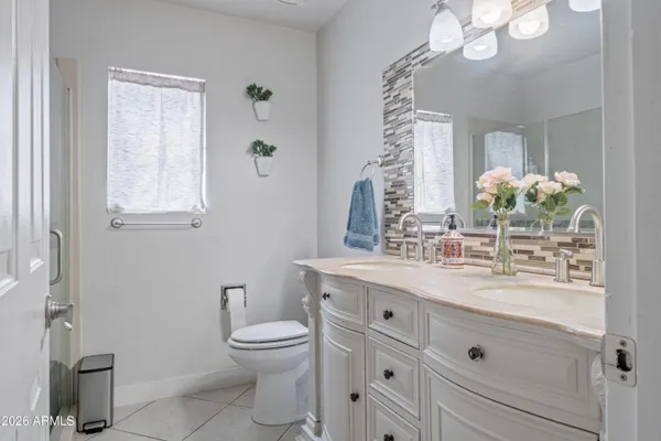 a bathroom with a granite countertop sink a toilet and a mirror