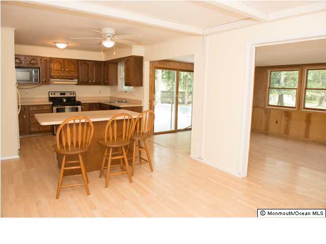 254 Lanes Pond Road Howell, NJ 07731 - Photo 7 of 16 a open kitchen with stainless steel appliances granite countertop a stove top oven a sink a dining table and chairs