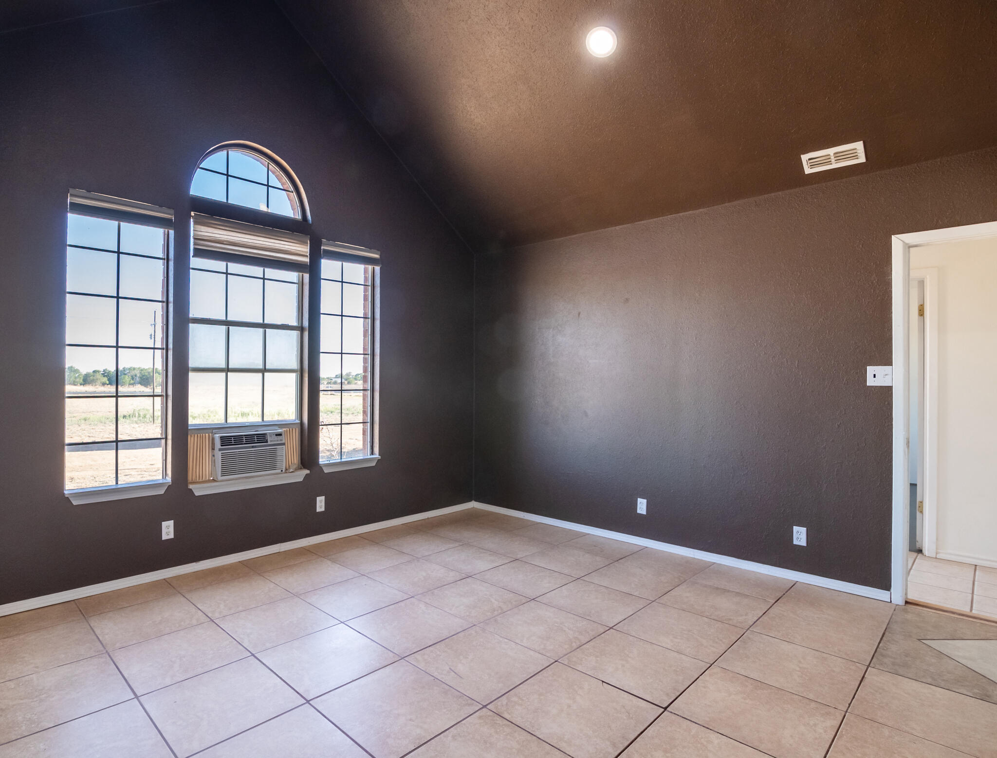 6917 Highway 114 Lubbock, TX 79407 - Photo 5 of 45 a view of an empty room with window and chandelier fan