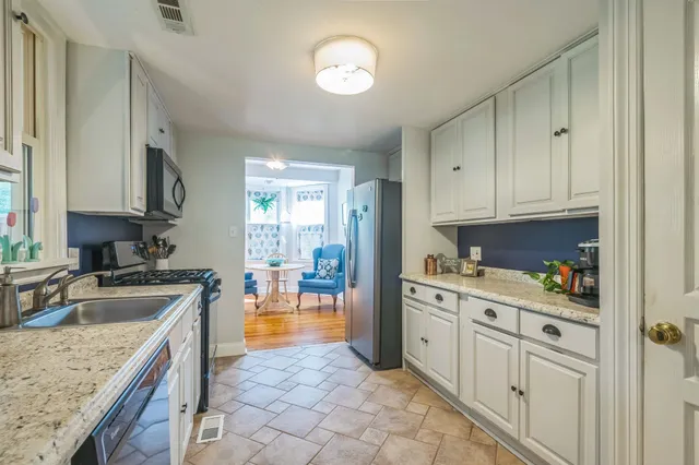 a kitchen with granite countertop a sink stove and cabinets