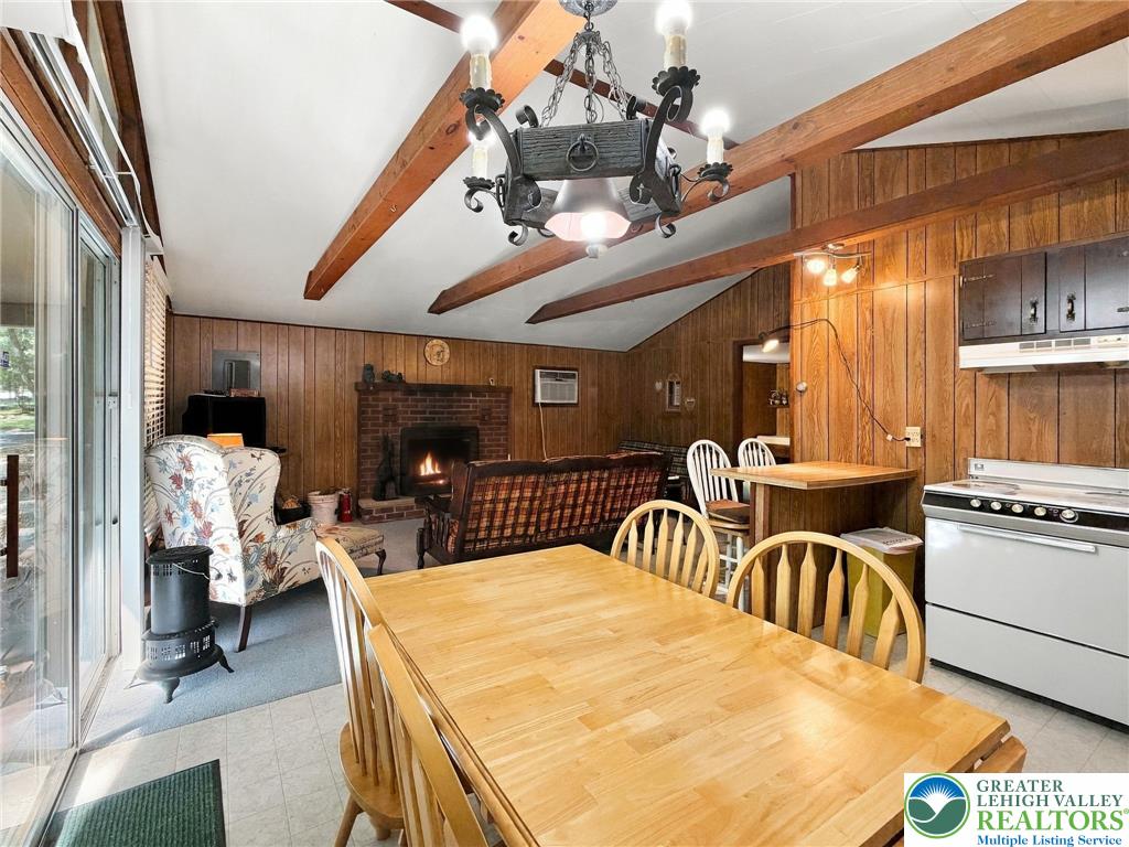 116 Aspen Road Albrightsville, PA 18210 - Photo 27 of 33 Exposed wood beams and wood-paneled walls frame a cozy open-concept living space.