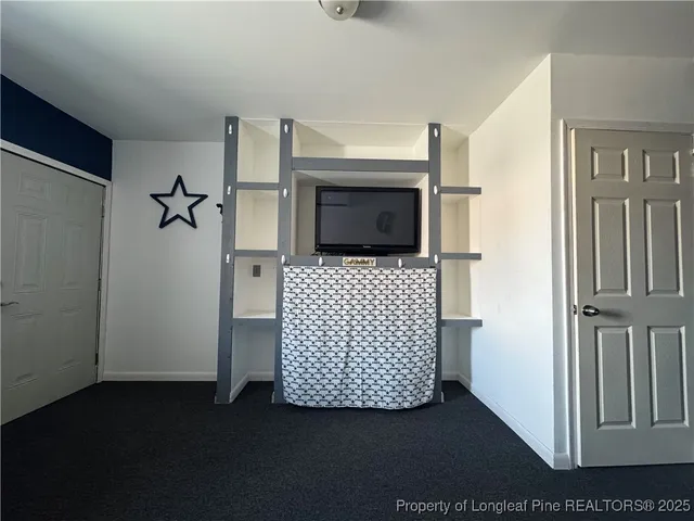 a view of a hallway with wooden floor and cabinet