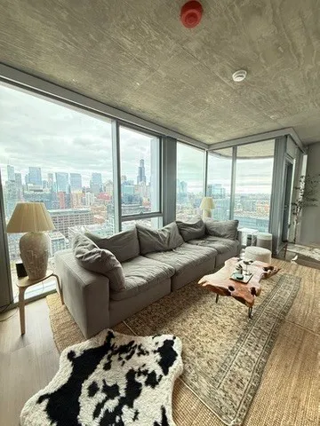 a living room with furniture and a floor to ceiling window