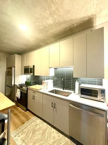 a kitchen with stainless steel appliances a stove sink and cabinets
