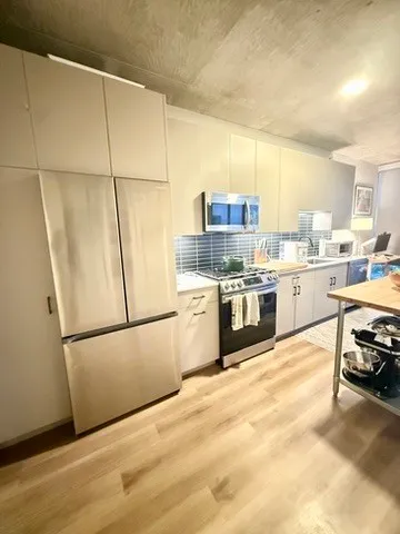 a kitchen with a refrigerator a stove a sink dishwasher and a refrigerator with wooden floor